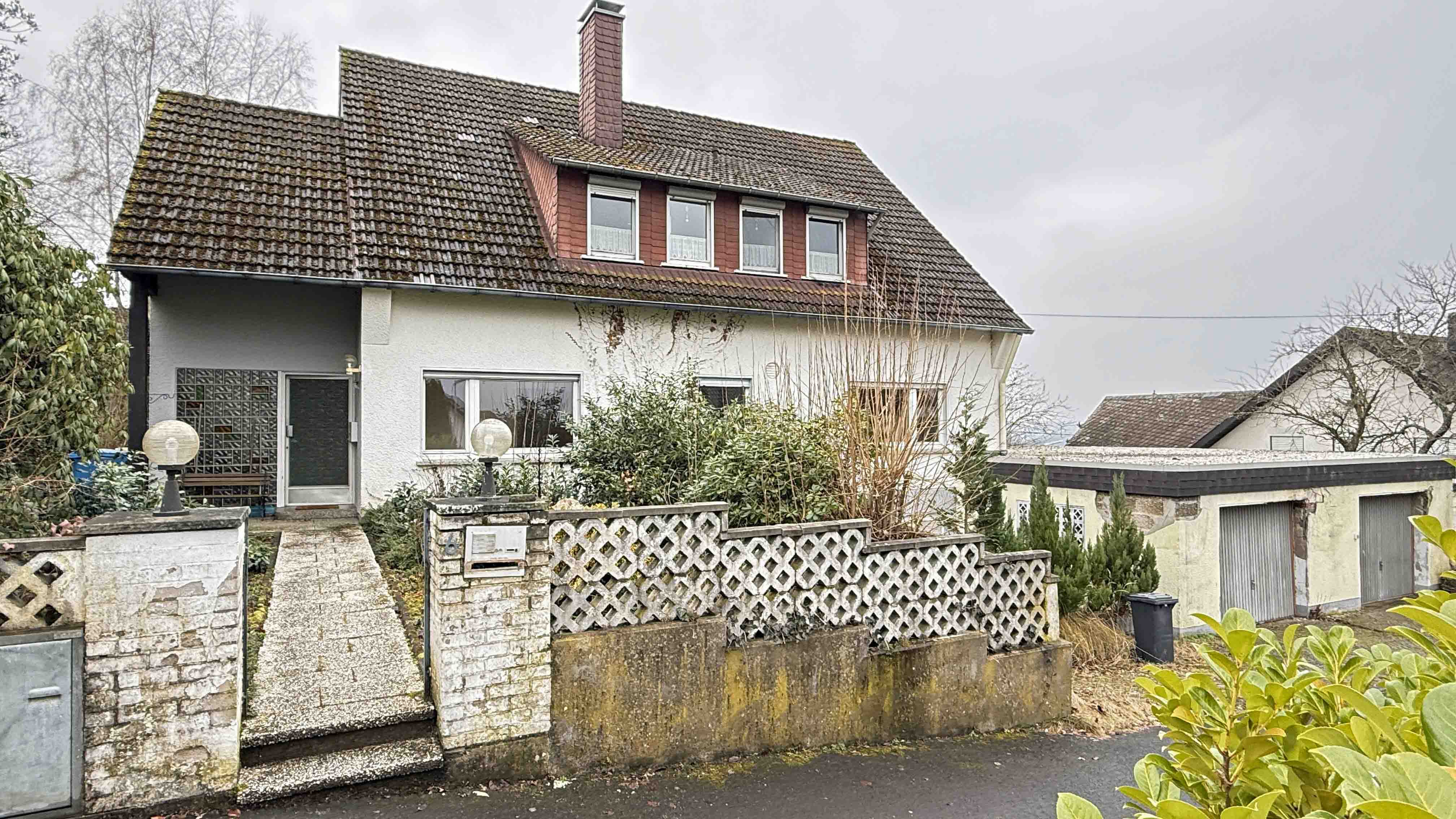 Wissen: Zweifamilienhaus im Dornröschenschlaf in bester Wohnlage, Frontansicht mit Doppelgarage (ebenerdig)