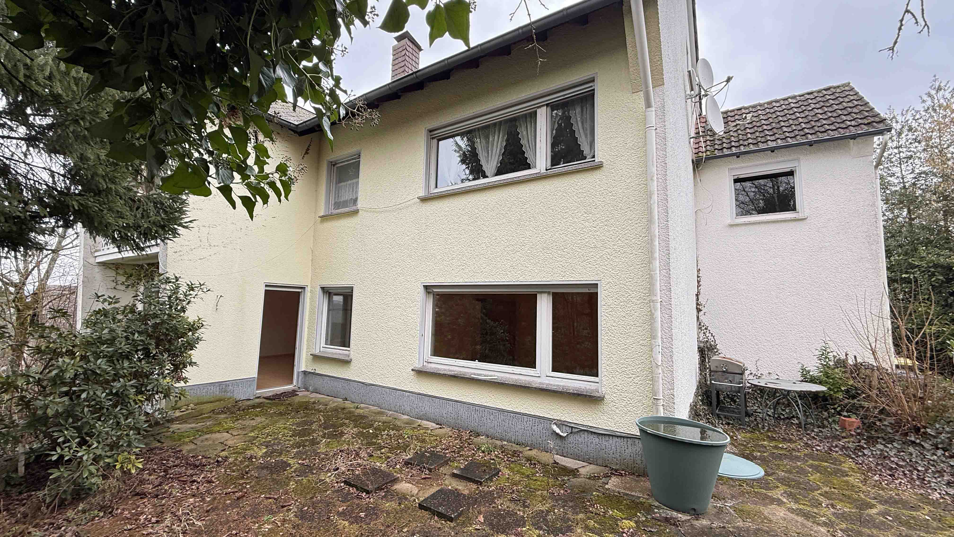 Wissen: Zweifamilienhaus im Dornröschenschlaf in bester Wohnlage, Hausrückseite mit Terrasse (Süd-/Westen) 